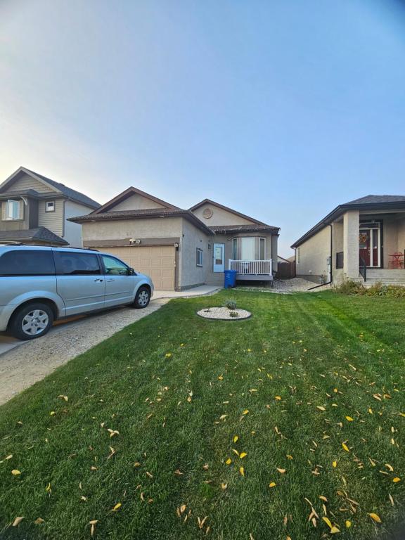 a car parked in front of a yard with houses at Home in Winnipeg