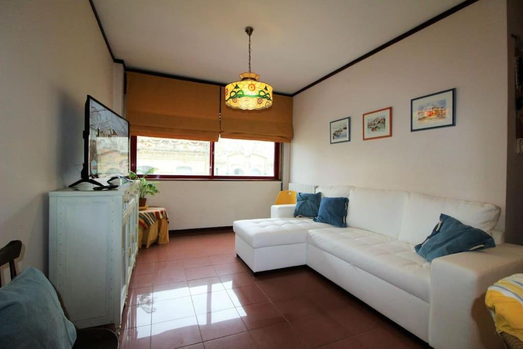 - un salon avec un canapé blanc et une fenêtre dans l'établissement Apartamento Figueira da Foz - Praia do Relógio, à Figueira da Foz