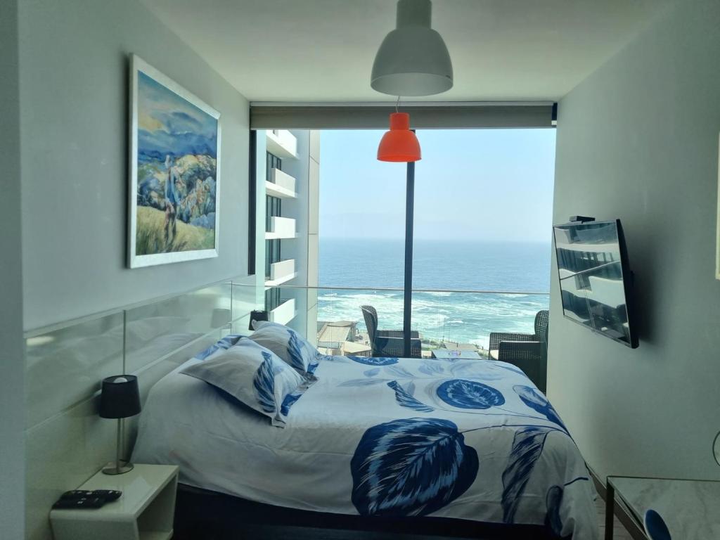 a bedroom with a bed with a view of the ocean at Puerto Nuevo Antofagasta in Antofagasta