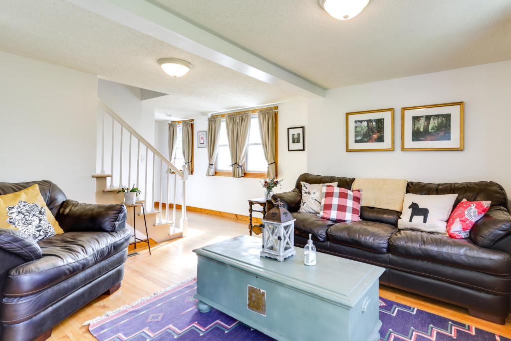 a living room with leather couches and a coffee table at Cozy Exeter Vacation Rental with Grill and Fire Pit in West Greenwich