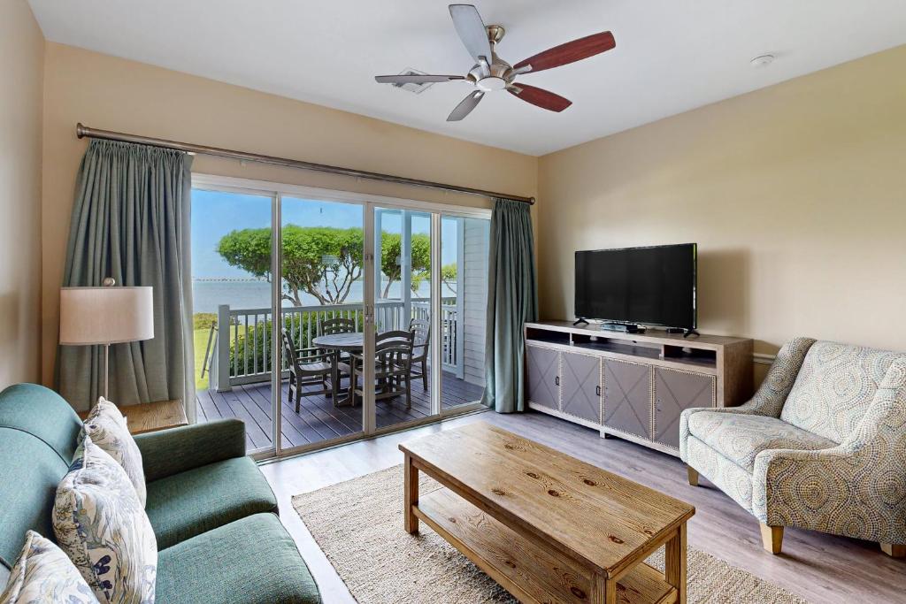 a living room with a couch and a flat screen tv at Reef House in Duck Key