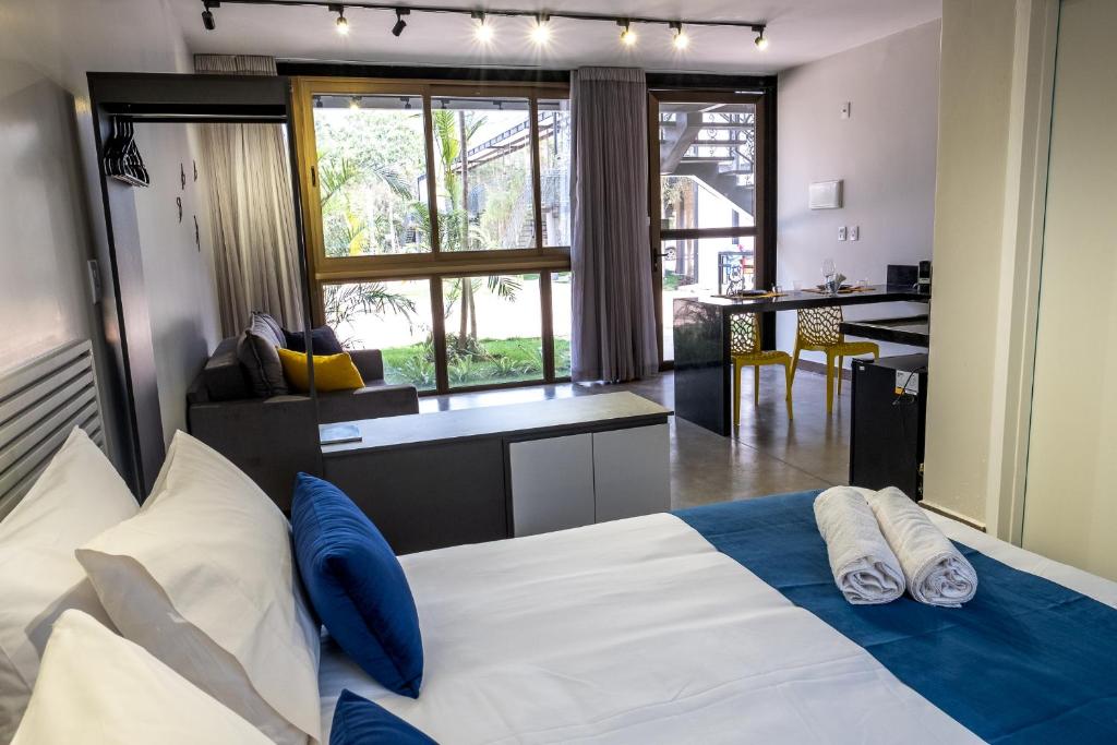 een slaapkamer met een groot wit bed met blauwe kussens bij Ecolounge Studios in Pirenópolis