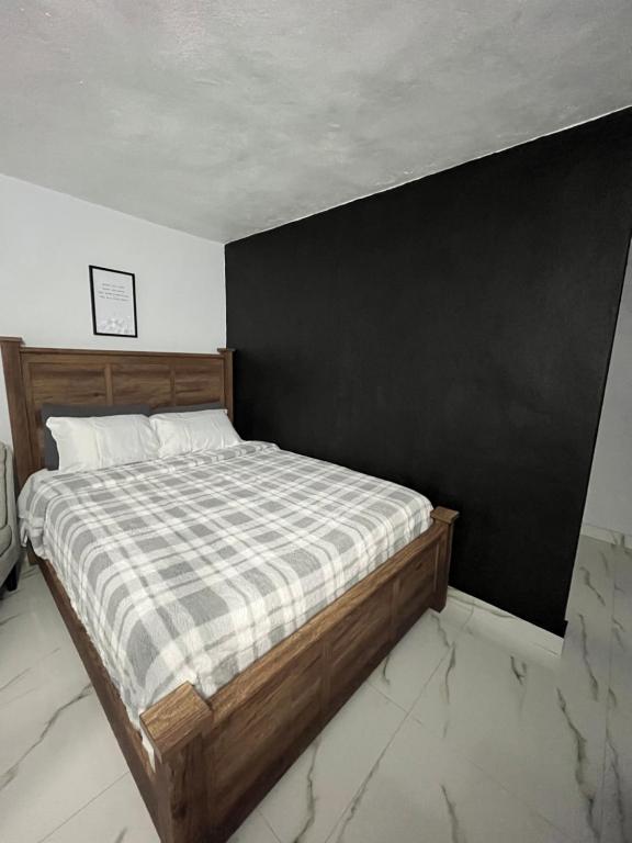 Bett in einem Zimmer mit schwarzer Wand in der Unterkunft Molino’s House 4 in Santa Isabel