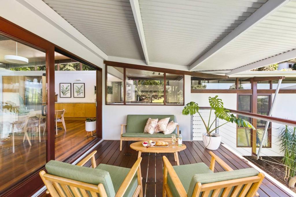 een afgeschermde veranda met stoelen en een tafel bij Coledale Rainforest Escape - A Tropical Beach Haven in Coledale