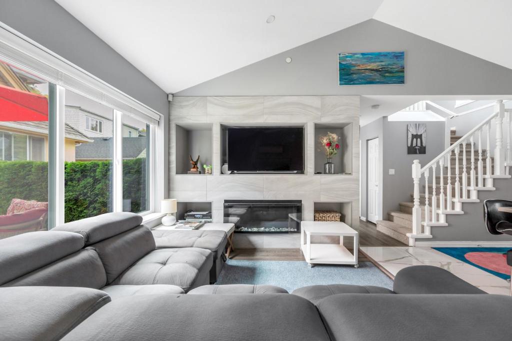 a living room with a couch and a tv at Stylish Dual Bedroom Suite in Van West in Vancouver