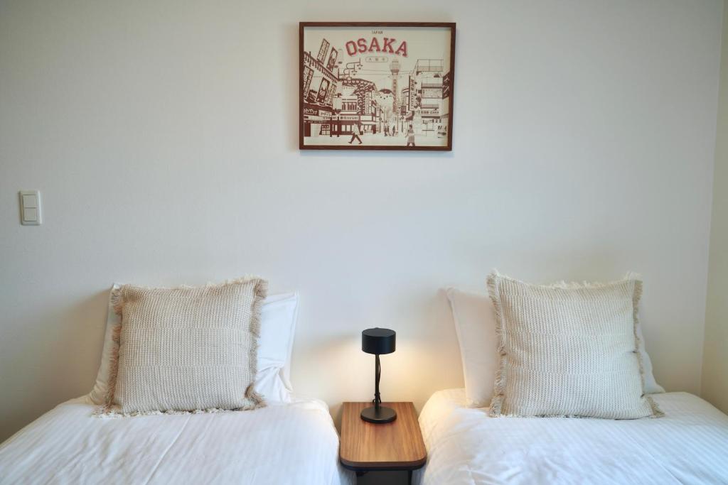 two beds sitting next to each other in a room at 川HOUSE旭 in Osaka