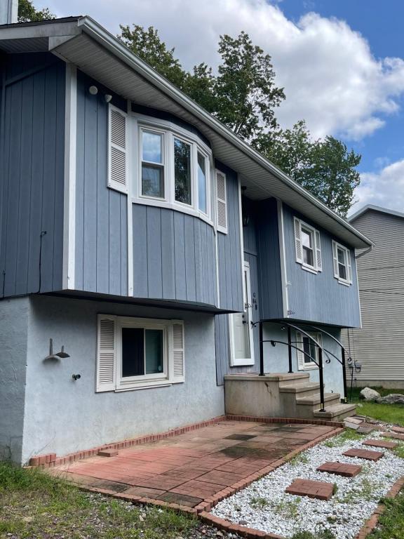 Cette maison bleue dispose de fenêtres blanches et d'une terrasse. dans l'établissement Home in Tobyhanna, Poconos Mountain, Pennsylvania, à Tobyhanna