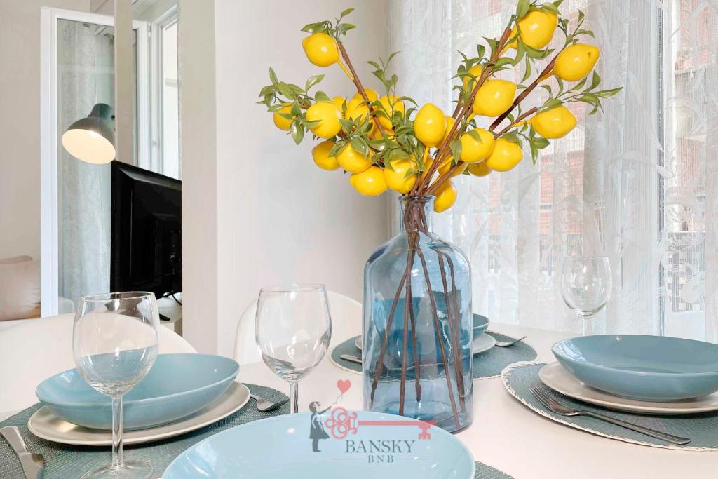 une table avec un vase et un bouquet d'oranges dans l'établissement Lime Splendido x4PAX Lugano City, à Lugano