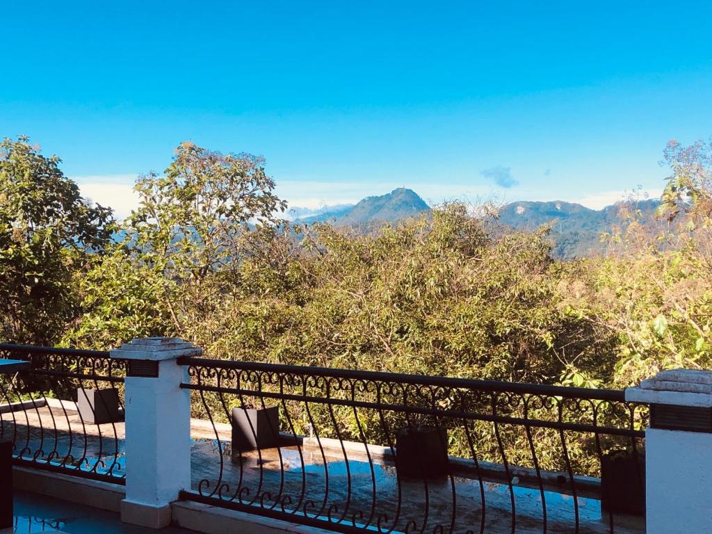 a balcony with chairs and a view of the mountains at Elegant Hotel in Kandy
