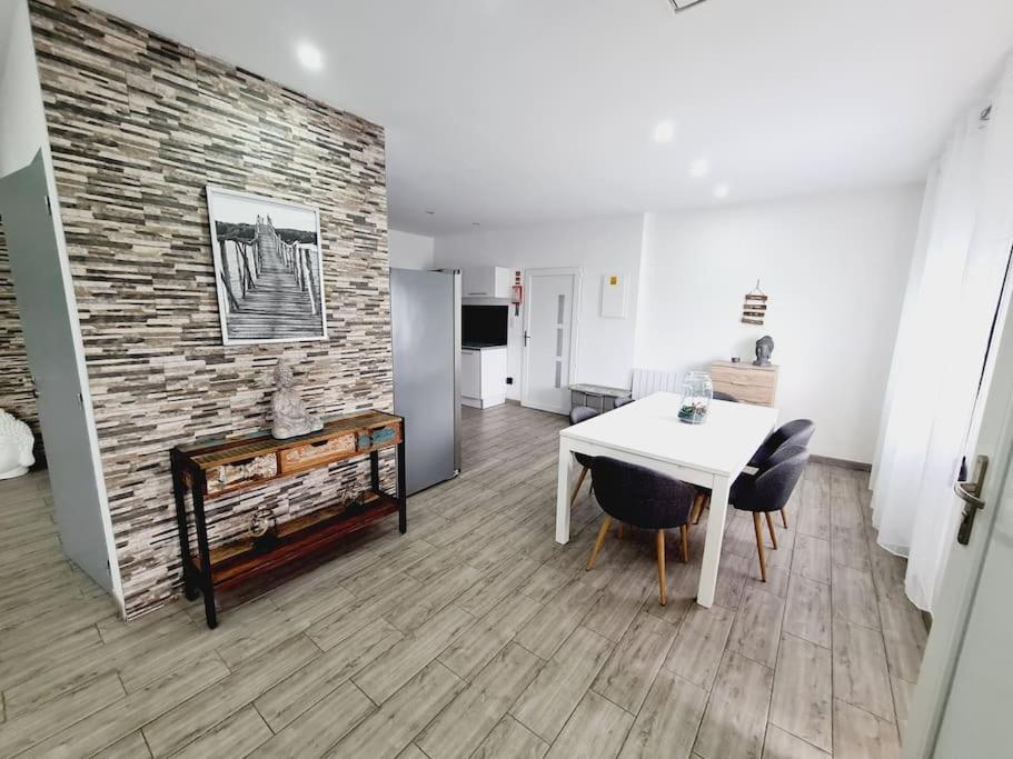 ein Wohnzimmer mit einem weißen Tisch und einer Ziegelwand in der Unterkunft GuestHouse dos Limites in Espinho