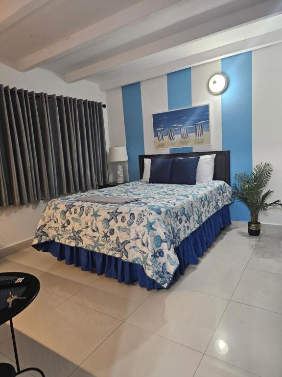 a bedroom with a bed with a blue wall at STARFISH LUXURY APARTMENT in San Juan