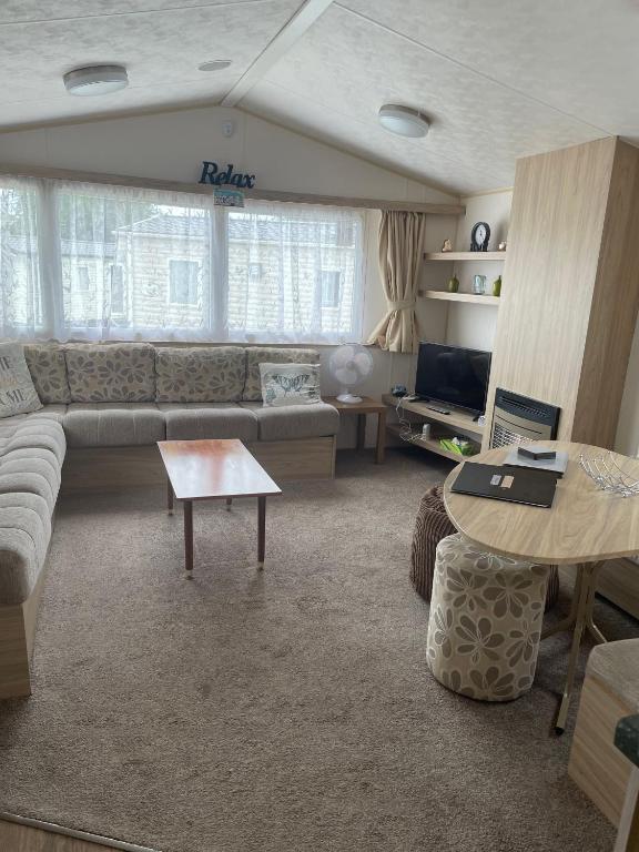 a living room with a couch and a table at Parkdean Static caravan on cherry tree holiday park in Great Yarmouth
