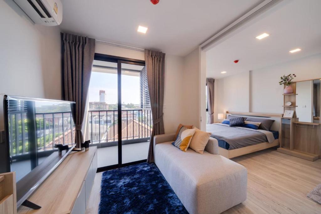 1 dormitorio con cama y ventana grande en Marvest Hua Hin, en Hua Hin