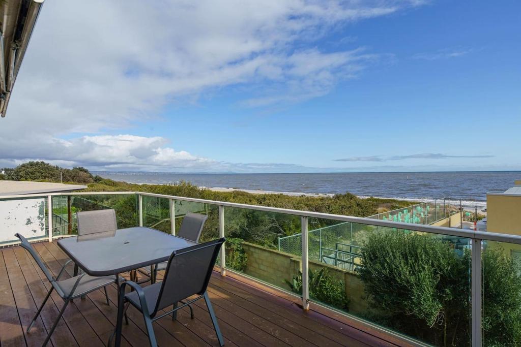 balcón con mesa, sillas y vistas al océano en Beachfront at Bonbeach - A Coastal Lifestyle Gem, en Bonbeach