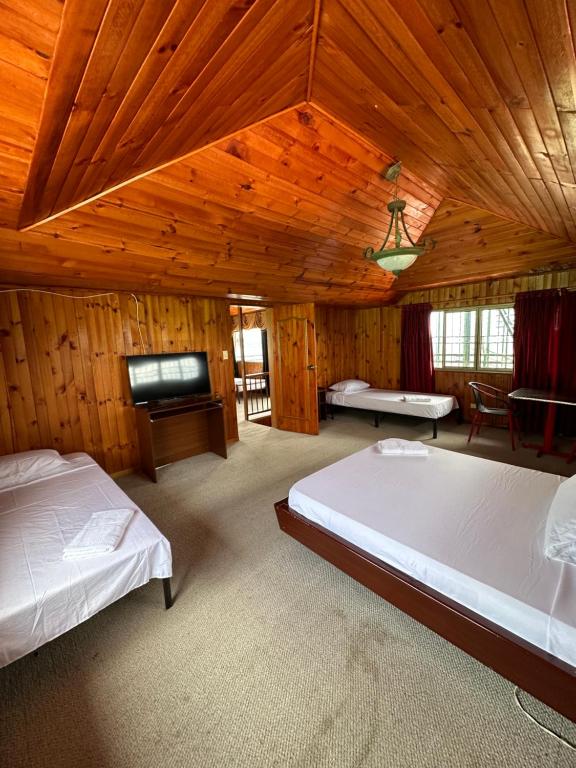 a bedroom with two beds and a flat screen tv at Eco Hotel La Selecta Campestre in Pereira