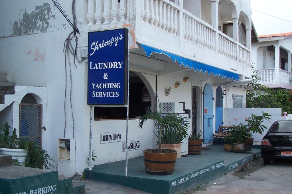 a blue sign in front of a building at Shrimpy's Hostel, Crew Quarters and Laundry Services in Marigot