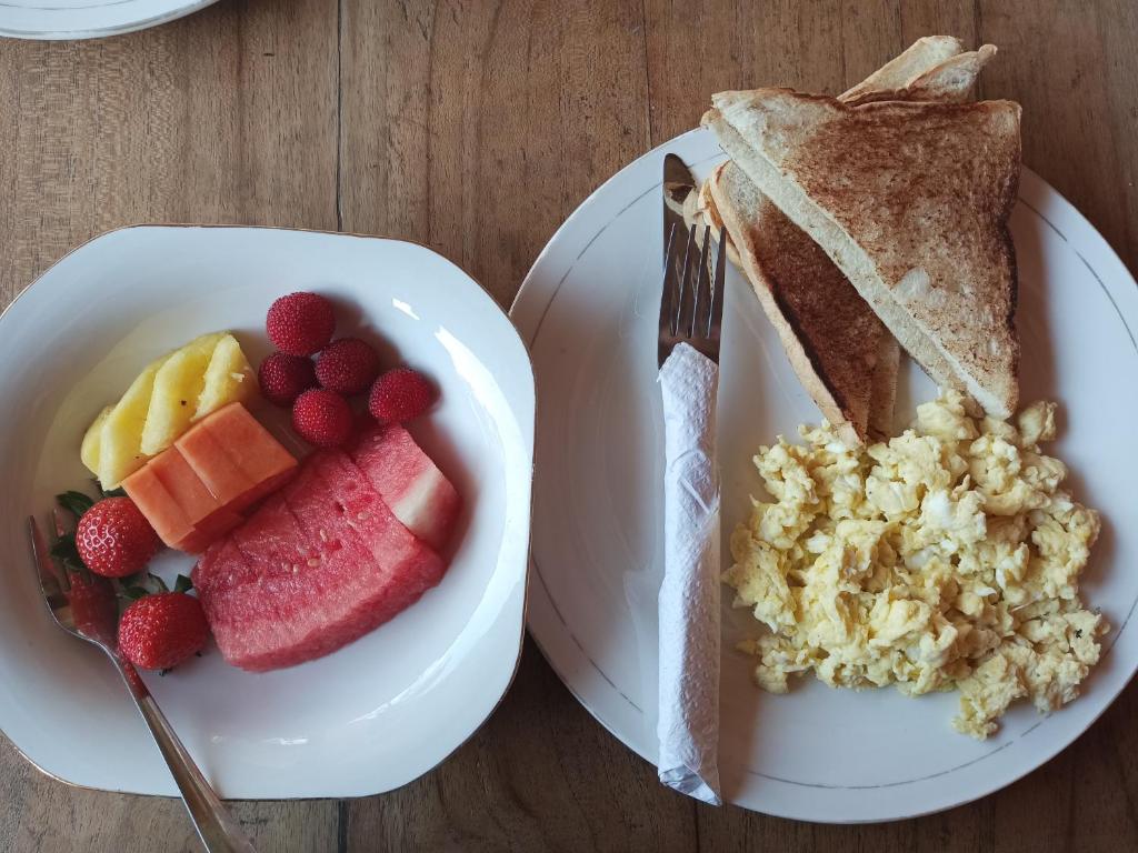 a plate of food with fruit and a sandwich at Pondok isoke in Banyuwangi