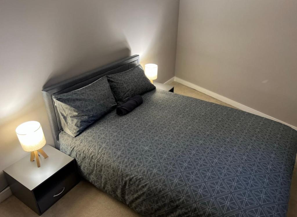 a bedroom with a bed with two lamps on it at Modern Room with Private Bathroom in Croydon