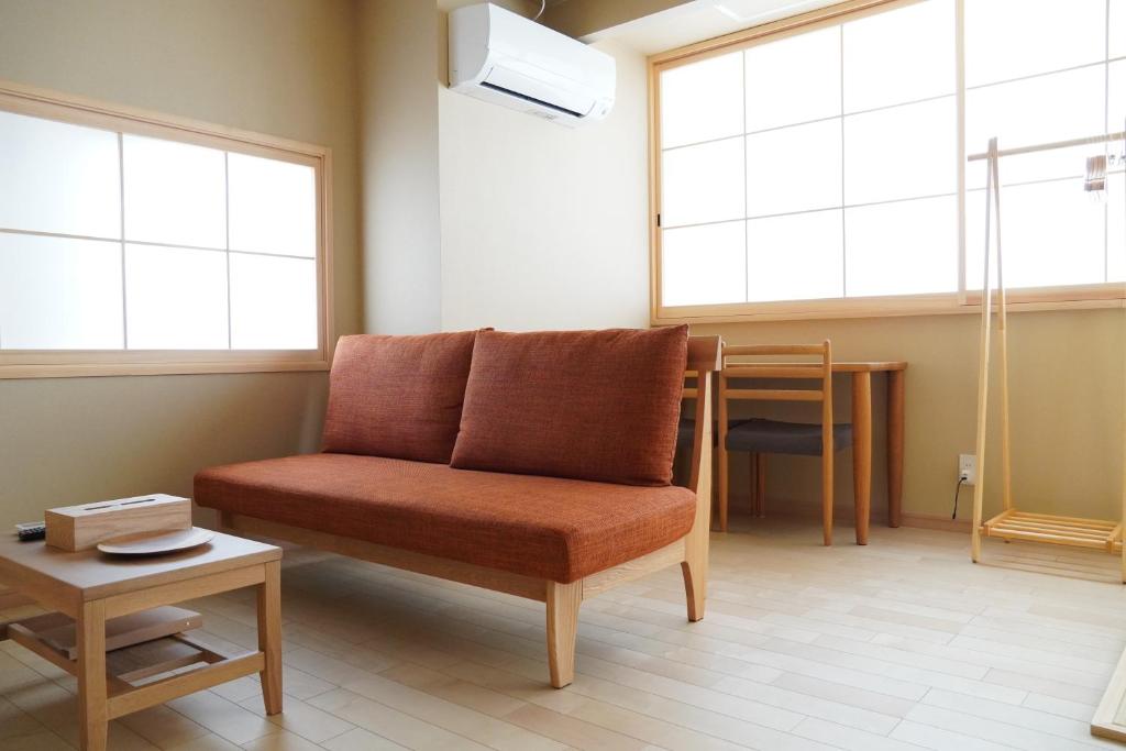 ein Wohnzimmer mit einem Sofa und einem Tisch in der Unterkunft RIKKA HANASATO in Takayama