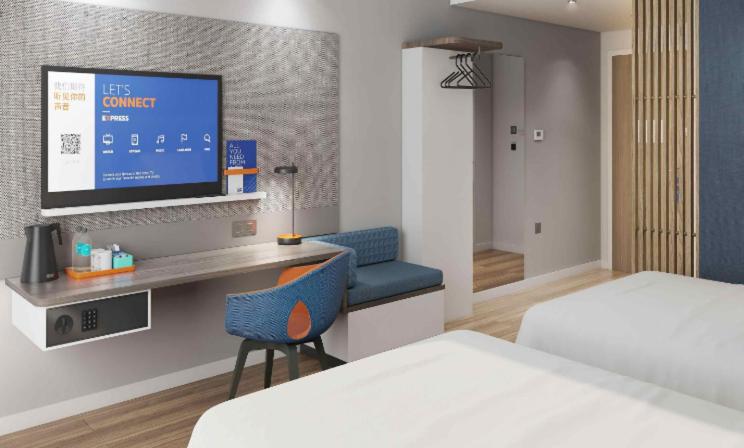 蘇州市にあるHoliday Inn Express Suzhou Fenhu by IHGのベッド2台とテレビ付きの机がある部屋