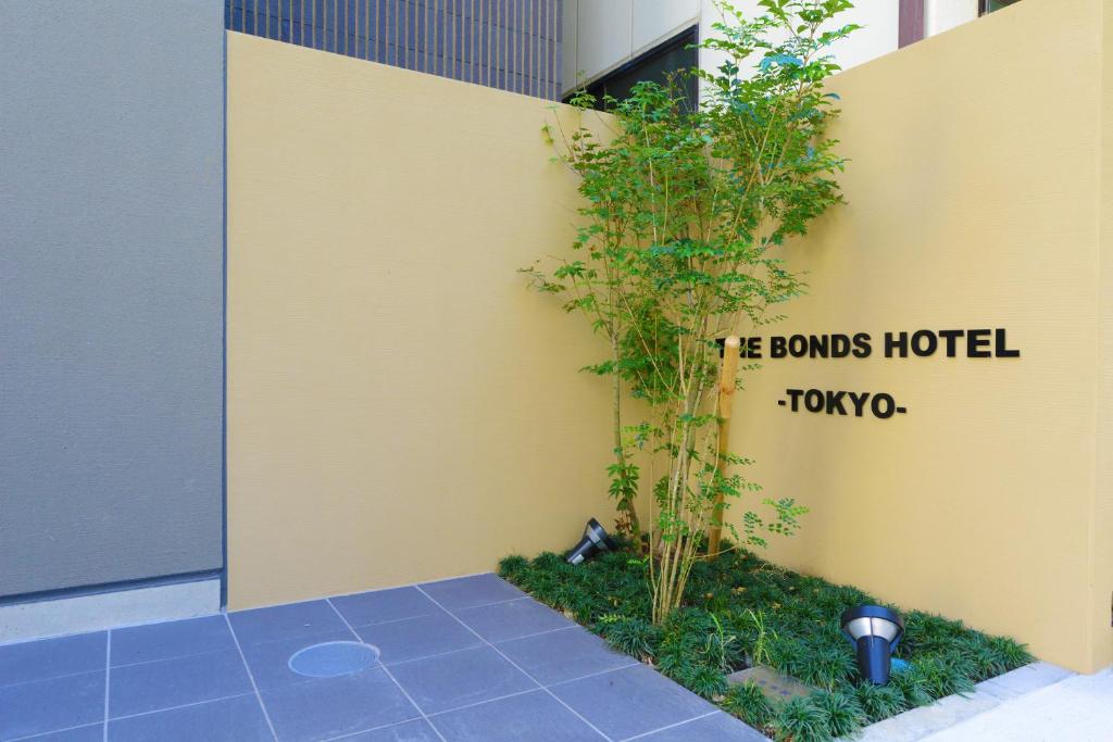 a yellow wall with a sign that reads he bonds hotel tokyo at THE BONDS HOTEL TOKYO in Tokyo
