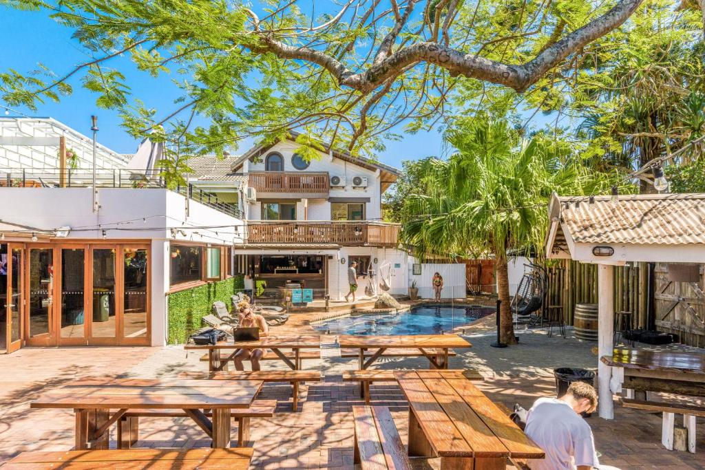 a patio with picnic tables and a swimming pool at Aquarius Backpackers Resort in Byron Bay