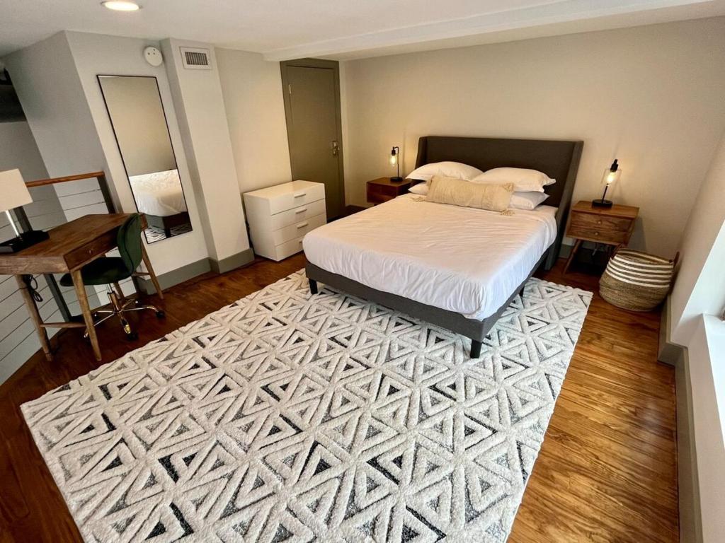 a bedroom with a bed and a white rug at Exceptional 1 Br Apartment Downtown W Study Loft in Roanoke