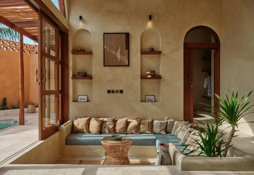 a living room with a blue couch in a house at Lina Boutique Villas and Spa in Kuta Lombok