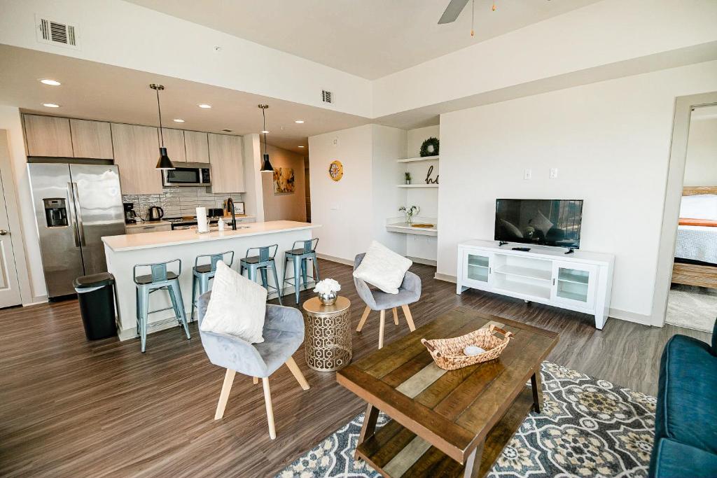 a living room with a couch and a kitchen with a table at Corporate Uptown Furnished Apartments in Charlotte