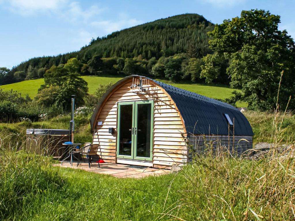 una pequeña cabaña de madera en un campo de hierba en Barcud Coch - Uk44539, en Hirnant