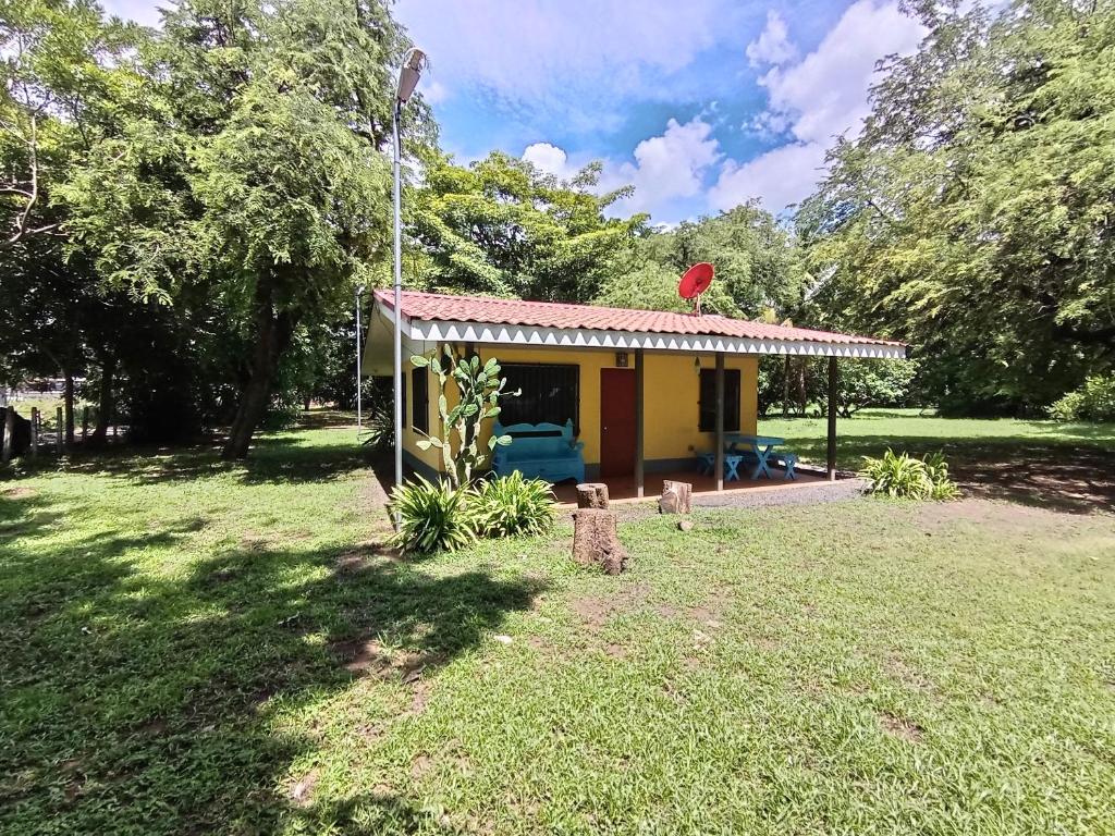 a small house in a field with a yard at Iguana Street Houses in Coco