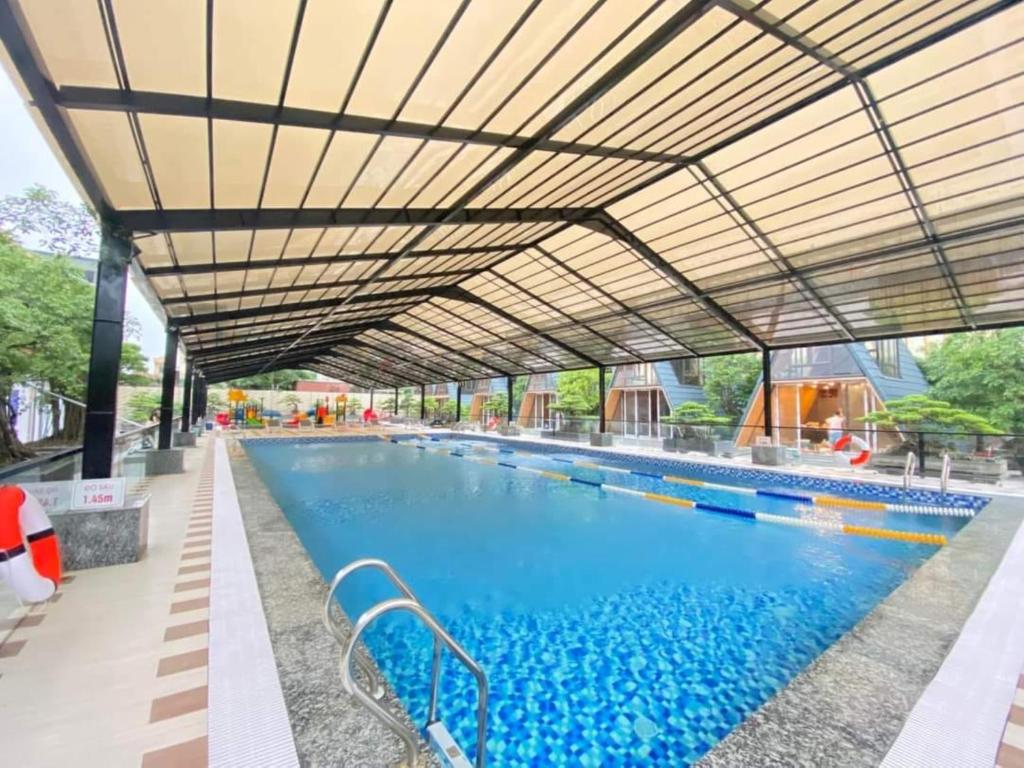 a large swimming pool with awning over it at Sunny Bungalow Ninh Bình in Ninh Binh