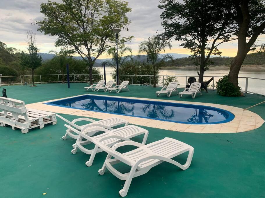 - un groupe de chaises longues blanches et une piscine dans l'établissement Casa Cabra Corral, à Coronel Moldes