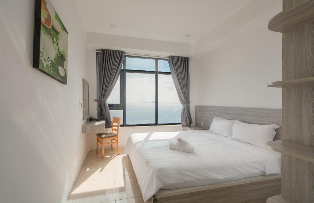 um quarto com uma cama e uma janela grande em Căn hộ Mường Thanh Viễn Triều - Review Nha Trang em Nha Trang