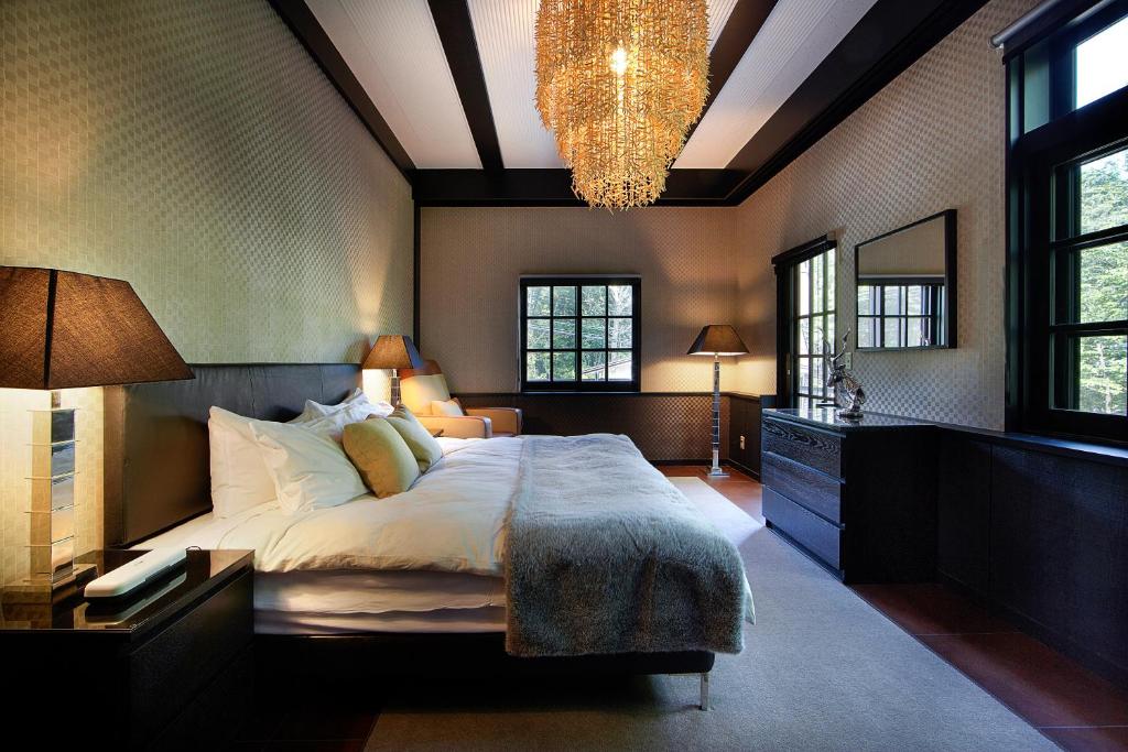 a bedroom with a large bed and a chandelier at Hakuba Mountain Lodge in Hakuba