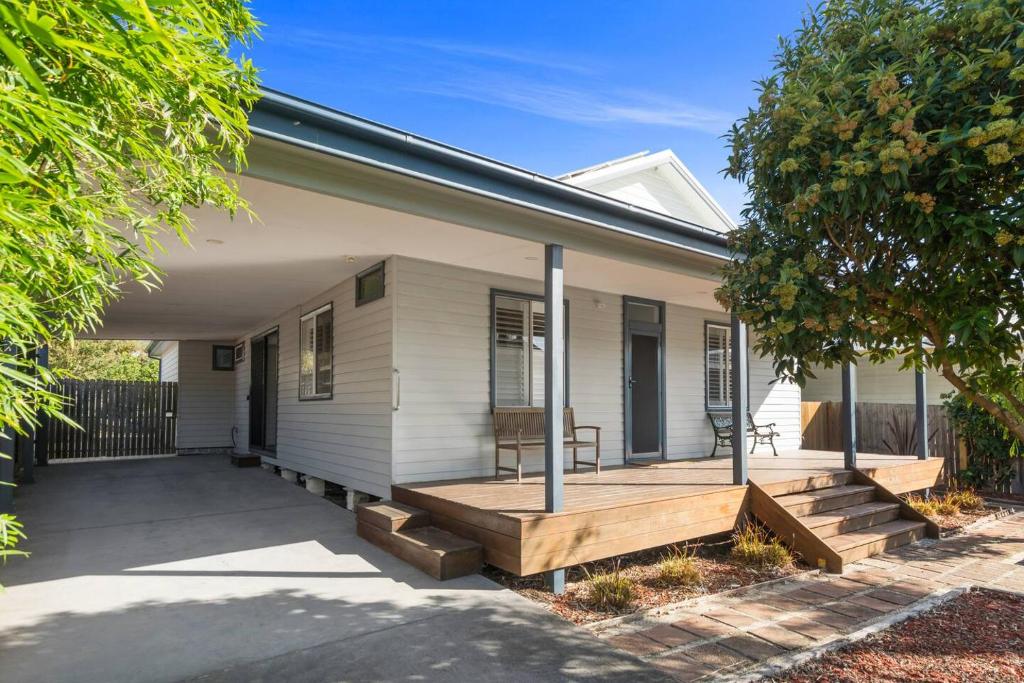 a house with a porch with a wooden deck at Ocean Blue Escape - Beachside Living & Granny Flat in Wollongong