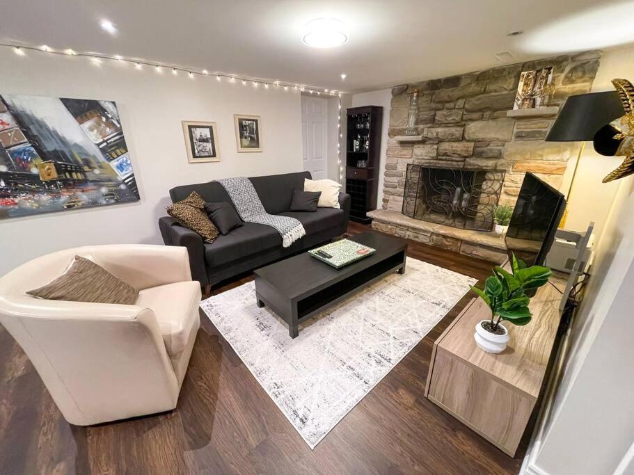 a living room with a couch and a fireplace at Spacious & Renovated 1BD Suite w/parking in Toronto