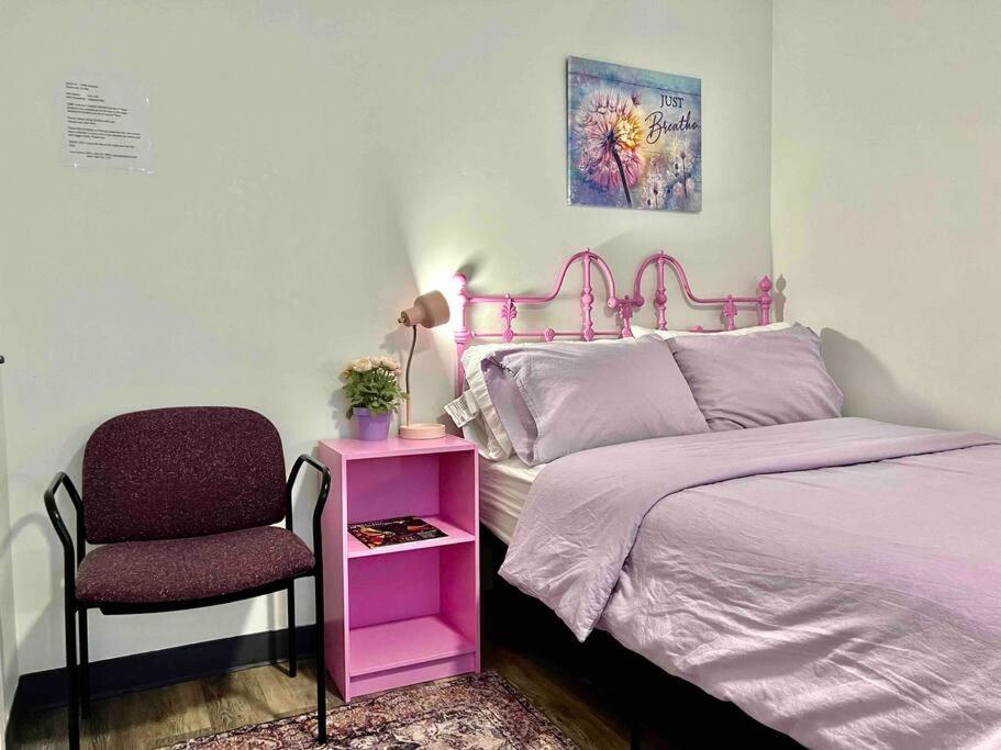 a bedroom with a pink bed and a chair at Apartment Studio with Shared Bathroom on the 1st Floor 10 minutes walk to University of WA in Seattle