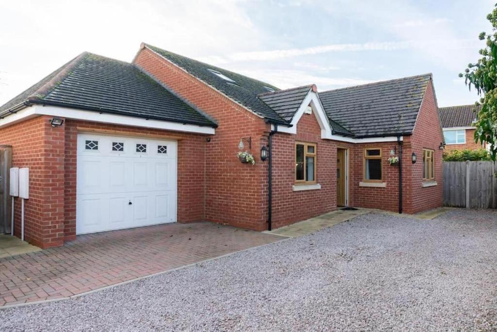 a red brick house with a white garage at Modern 4 Bed Detached Private House-Parking-Garden in Down Hatherley