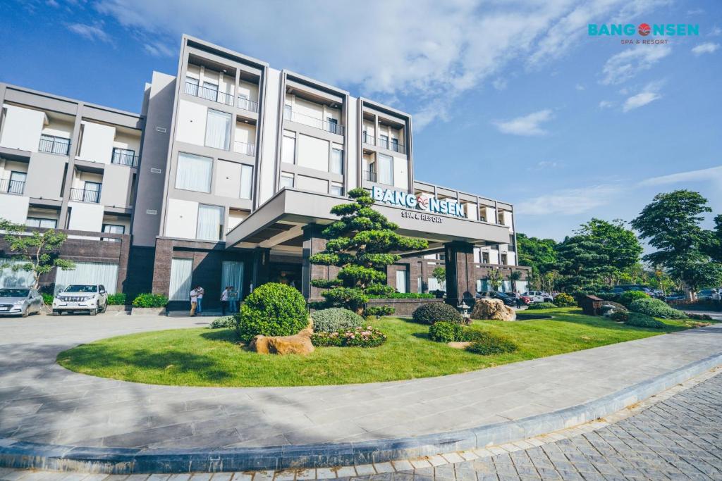 a large white building with a tree in front of it at Bang Onsen Spa & Resort in Bang