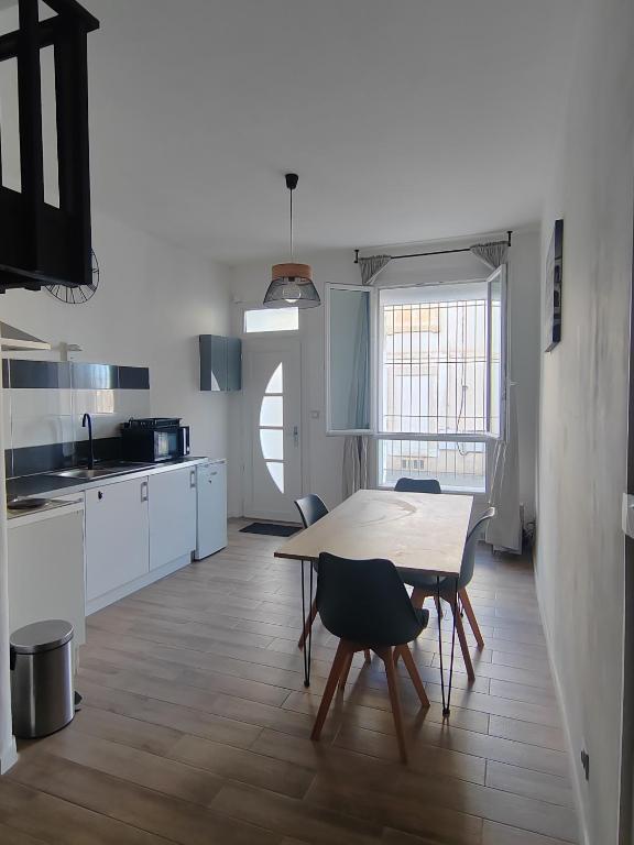 une cuisine avec une table et des chaises dans une pièce dans l'établissement Bel appartement, à Nîmes
