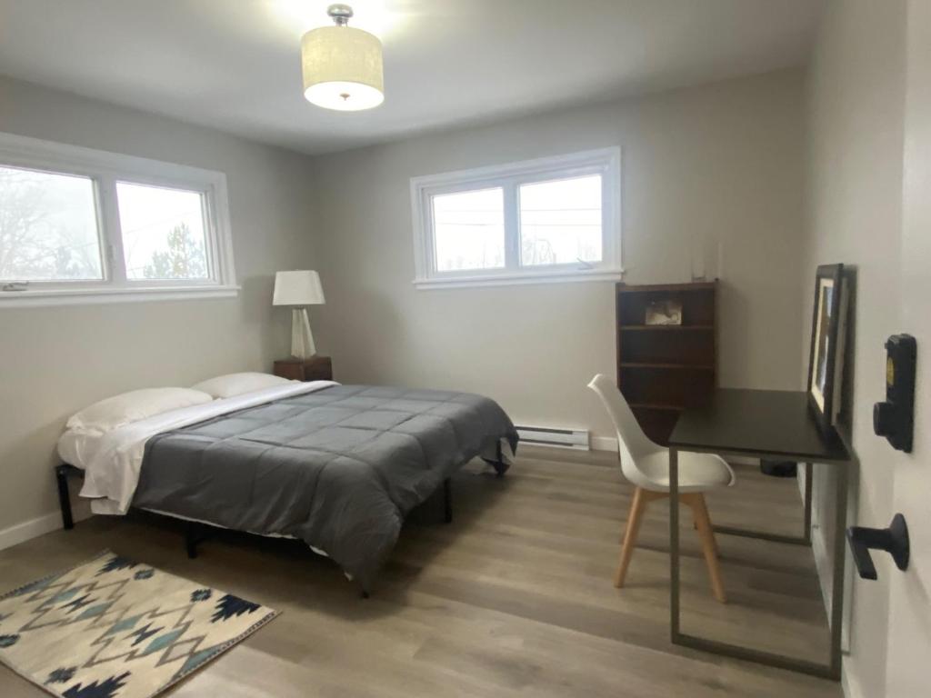 Schlafzimmer mit einem Bett, einem Schreibtisch und einem Stuhl in der Unterkunft Private Room Lakeview House- Westmount in Moncton