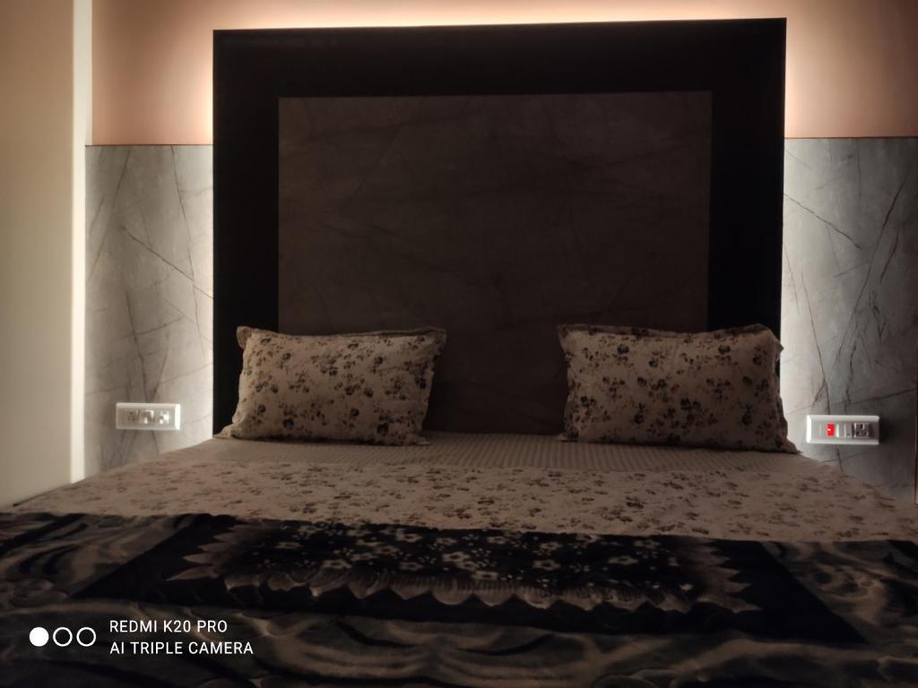 a bed with a black headboard and two pillows at WinterValleyChail in Shimla