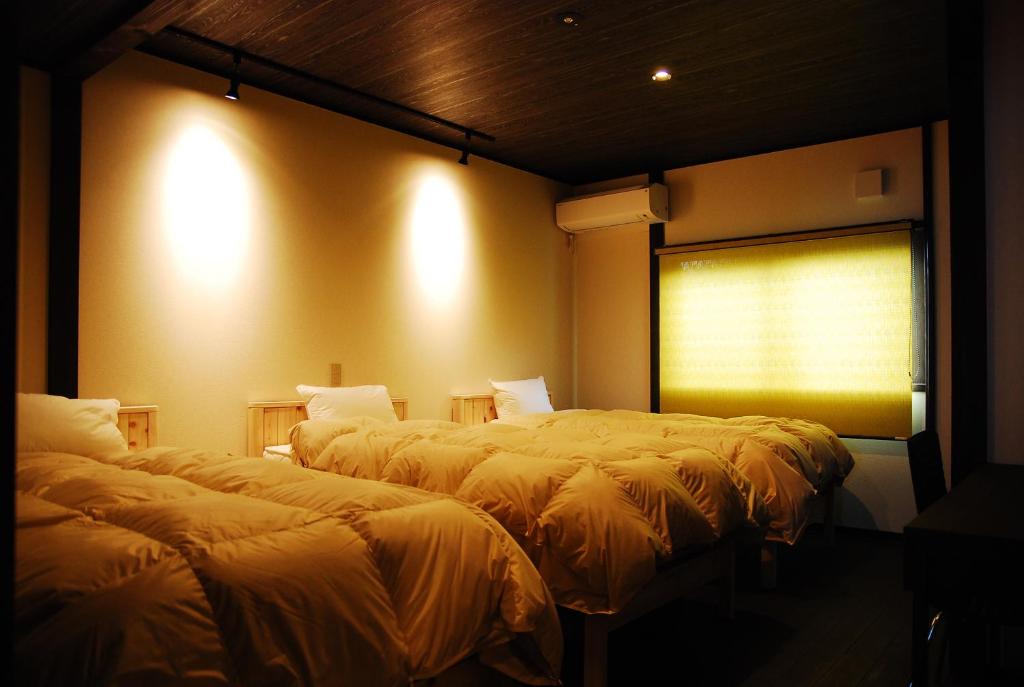 una camera con due letti e una finestra con luci di 金沢一棟宿 海泉 Restoring In Kanazawa KAISEN a Kanazawa