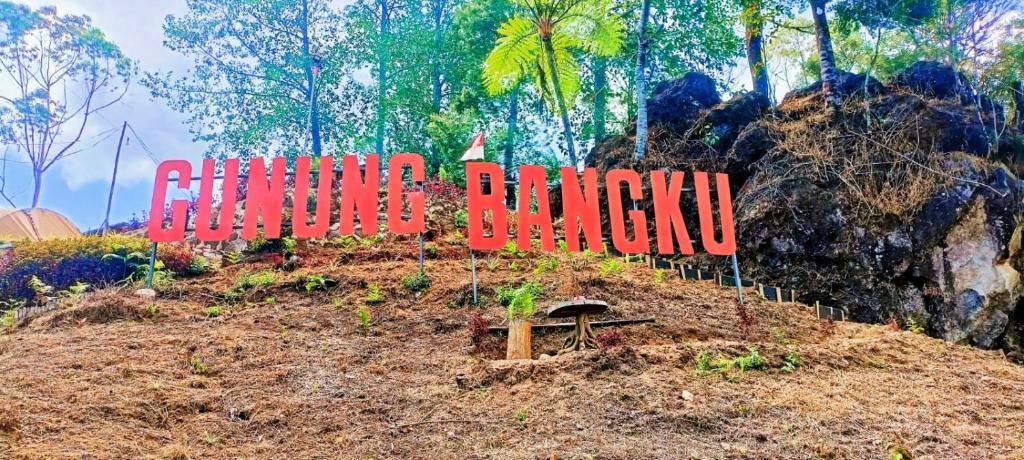un cartello in cima a una collina con alberi sullo sfondo di Gunung bangku ciwidey rancabali camp a Ciwidey