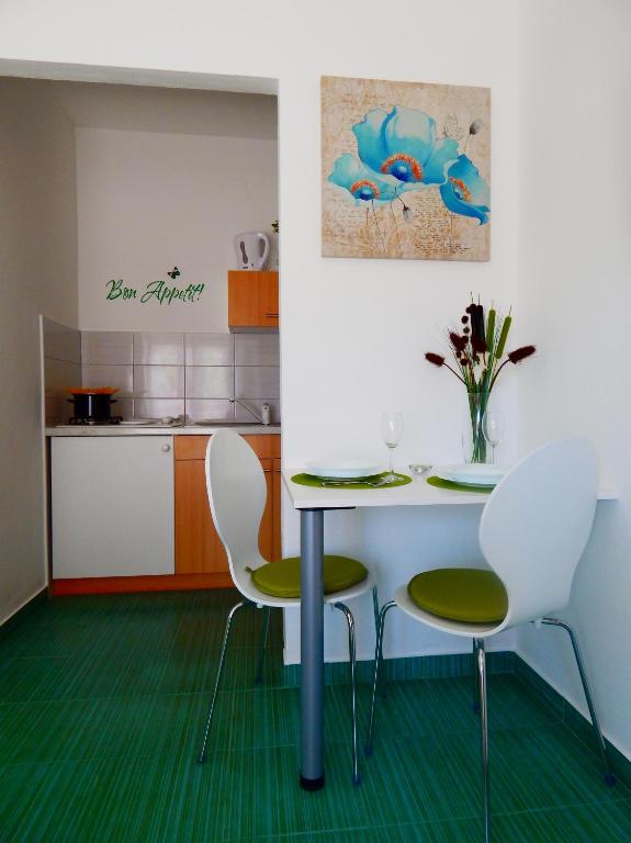jadalnia ze stołem i krzesłami oraz kuchnia w obiekcie Apartments & Rooms Marinka w mieście Zadar