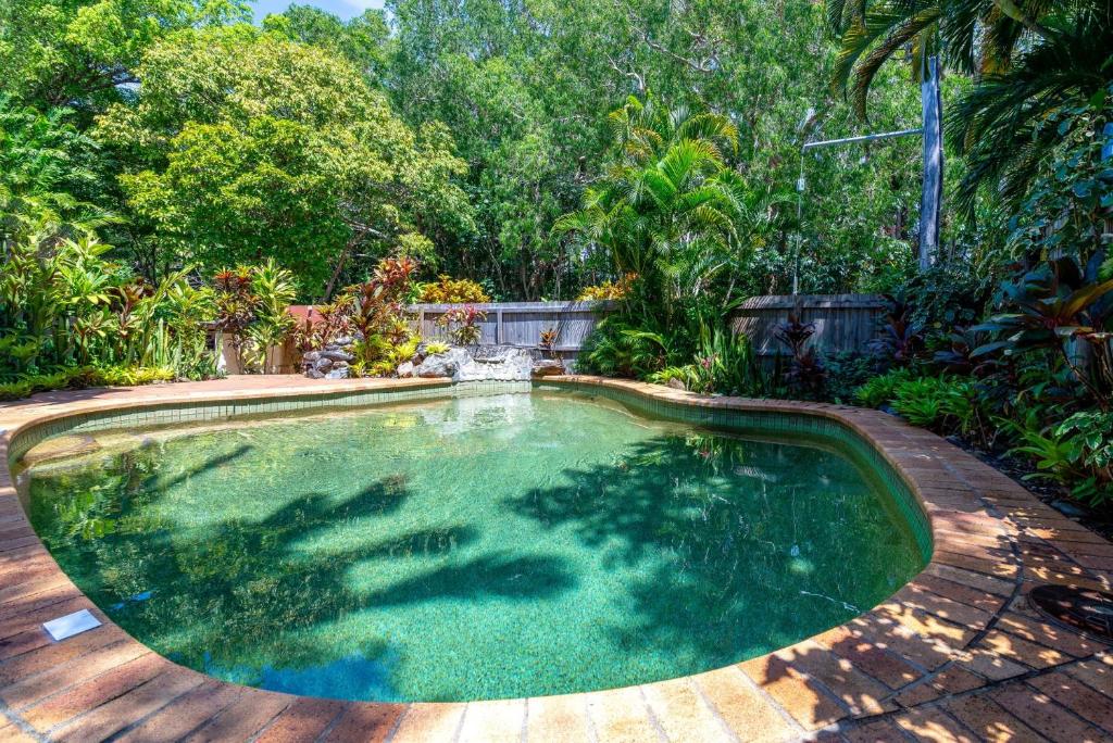 una pequeña piscina en un patio trasero con árboles en Villa 5 Marlin Terraces, en Port Douglas