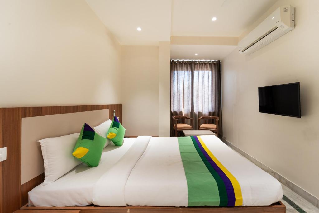 Un pat sau paturi într-o cameră la Treebo Trend Kaveri