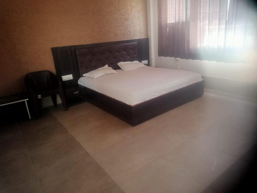 um quarto com uma cama e uma cadeira em Lakshya Resort em Dīgod