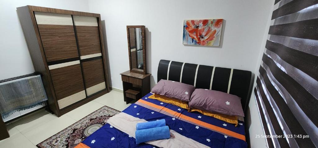 1 dormitorio con 1 cama con almohadas moradas en D'Haty Homestay, en Padang Serai